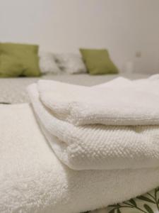 a stack of white towels on a bed at B&B Civico 226 in Sesto San Giovanni