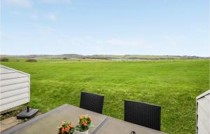 a table and chairs with a large field in the background at Gorgeous Apartment In Lemvig in Lemvig