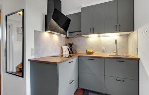 a kitchen with white cabinets and a sink and a mirror at Gorgeous Apartment In Lemvig in Lemvig