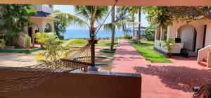 a hammock in the middle of a courtyard with palm trees at Seashore Beach Resort Varkala in Varkala