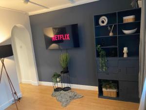 a room with a shelf with a netflix sign on it at Prettide Suite - Free Parking in Gillingham