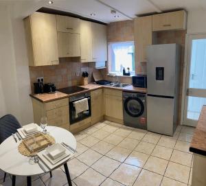 a kitchen with a table and a white refrigerator at Prettide Suite - Free Parking in Gillingham