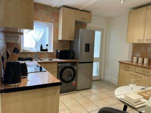 a kitchen with a refrigerator and a washing machine at Prettide Suite - Free Parking in Gillingham +15 photos