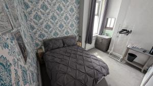 a bedroom with a bed in a room with wallpaper at Martell's Hotel in Blackpool