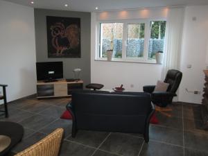 ein Wohnzimmer mit schwarzen Stühlen und einem TV in der Unterkunft Ferienwohnung Mauritiusstraße in Xanten