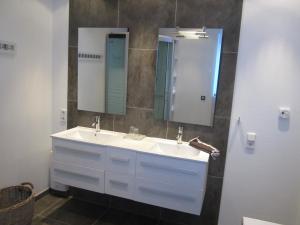 a bathroom with two sinks and two mirrors at Ferienwohnung Mauritiusstraße in Xanten