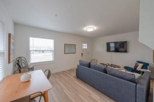 a living room with a blue couch and a tv at #StayInMyDistrict Coos Bay Indigo Cottage in Coos Bay