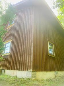 un edificio con dos ventanas laterales en Country Guest House, en Packules Ciems