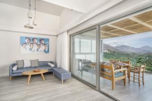 a living room with a blue couch and a table at New Seaview Villa Minoiko with Private Pool near the Beach in Plakias in Sellía