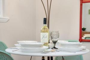 a white table with a bottle of wine and a glass at Old Town Retreat w Vintage Flair Near CSU, Bikes! in Fort Collins +19 photos