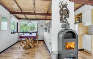 una cucina e una sala da pranzo con stufa a legna di Holiday Home Tovtvej Fanø Ii a Fanø