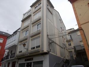 a white building with a balcony on the side of it at Apartamento Torreón in Foz