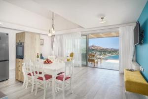 a kitchen and dining room with a white table and chairs at New seaview villa Venetsianiko with Private Pool & BBQ close to the beach in Sellía