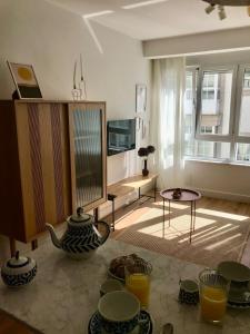 a living room with a table with bowls and vases at Apartamento Torreón in Foz