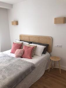 a bedroom with a bed with pink and white pillows at Apartamento Torreón in Foz
