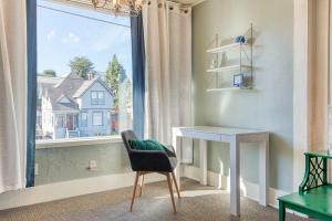 a room with a chair and a desk and a window at #StayinMyDistrict Heritage House Suite in Coos Bay