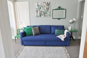 a blue couch in a living room with a table at #StayinMyDistrict Heritage House Suite in Coos Bay