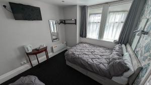 a small bedroom with a bed and a window at Martell's Hotel in Blackpool