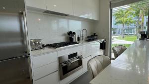 eine Küche mit weißen Schränken und einem Herd mit Backofen in der Unterkunft 2bdr Seven Mile Beach Corridor - ONE Canal Resort in George Town