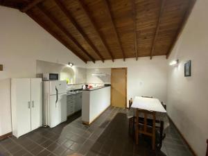 a kitchen with white appliances and a table in it at Departamento El Origen-SMA in San Martín de los Andes