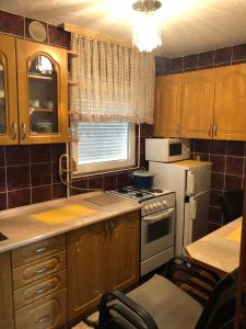 a kitchen with wooden cabinets and a white stove top oven at Apartments M&J in Sarajevo