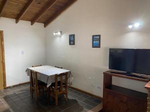 a dining room with a table and a flat screen tv at Departamento El Origen-SMA in San Martín de los Andes