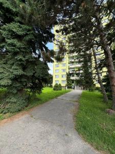 a path in front of a yellow building at Apartmán Radvaň in Banská Bystrica