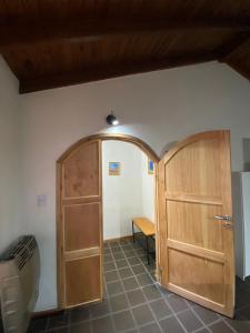 a room with a wooden door and a table at Departamento El Origen-SMA in San Martín de los Andes