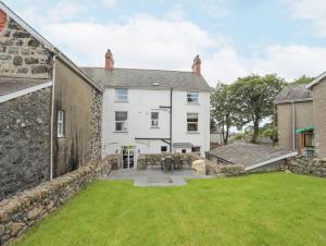 una vista exterior de una casa blanca con patio en Llwyn Onn, en Criccieth