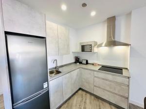 Una cocina con frigorífico de acero inoxidable y fregadero. en Marina Bay 1, en Benalmádena 10 fotos más