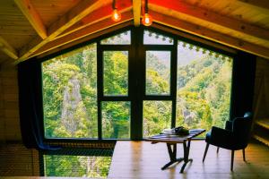 a large window in a room with a table and a chair at Depani Doğa Evleri in Kise