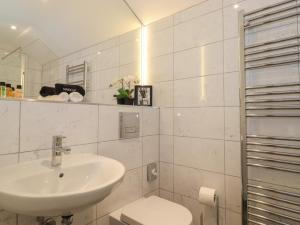a white bathroom with a sink and a toilet at Meadow Syke Barn in Penrith