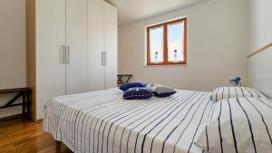 a bedroom with a bed with blue pillows on it at Fabiola in Karigador