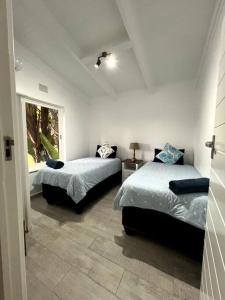 Un dormitorio con dos camas y una ventana. en San Lameer 3505 Oppi Dam, en Southbroom 48 fotos más