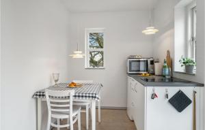 a kitchen with a table with chairs and a microwave at Awesome Apartment In Balle With Wifi in Vester Balle