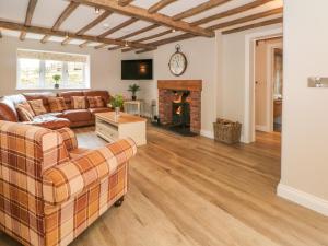 un soggiorno con divano e camino di Small Lane Cottage a Endon