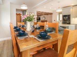 un tavolo in legno con sedie e una sala da pranzo di Small Lane Cottage a Endon