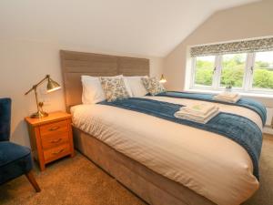 una camera da letto con un letto grande e una finestra di Small Lane Cottage a Endon