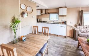 a kitchen and living room with a wooden table and chairs at 2 Bedroom Nice Home In Heinkenszand in Heinkensand