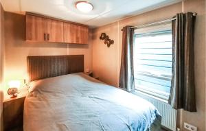 a bedroom with a large bed and a window at 2 Bedroom Nice Home In Heinkenszand in Heinkensand +34 photos