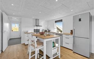 a kitchen with white cabinets and a white refrigerator at Nice Home In Tarm With Kitchen in Hemmet