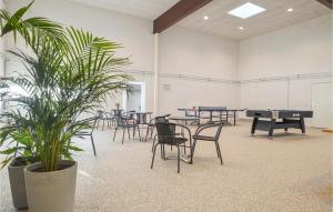a room with ping pong tables and chairs and a plant at Feriehotal Tranum Klit in Brovst