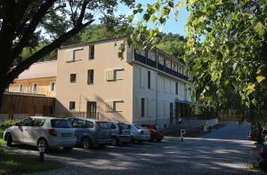 a building with cars parked in a parking lot at Mátraverebély-Szentkút Nemzeti Kegyhely in Mátraverebély