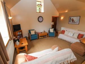 a living room with a couch and chairs at Henblas Cottage in Abergele