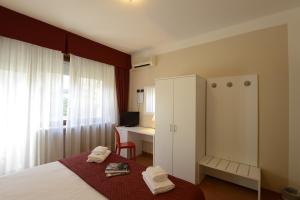 a bedroom with a bed with a cabinet and a desk at Hotel Tourist in Turin