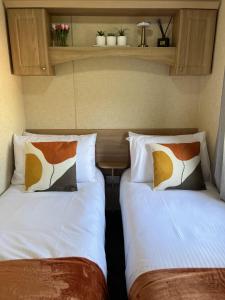 two beds sitting next to each other in a room at Hornshole Hideaway Caravan Hawick in Hawick +25 photos