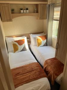 two twin beds in a small room withacers at Hornshole Hideaway Caravan Hawick in Hawick