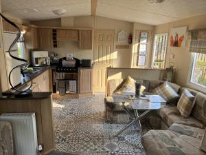 a living room with a couch and a table at Hornshole Hideaway Caravan Hawick in Hawick