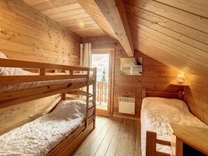 1 dormitorio con 2 literas en una cabaña de madera en Chalet cosy 2 étoiles, 9 pers, 4 ch, 2 sdb, terrasse sud, proche télésiège, commerces, piscine été - FR-1-417-5, en La Toussuire