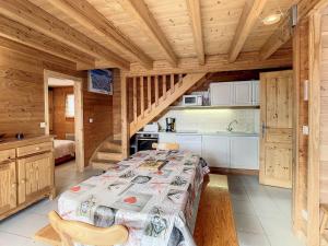 1 dormitorio con 1 cama y cocina en una cabaña en Chalet cosy 2 étoiles, 9 pers, 4 ch, 2 sdb, terrasse sud, proche télésiège, commerces, piscine été - FR-1-417-5, en La Toussuire